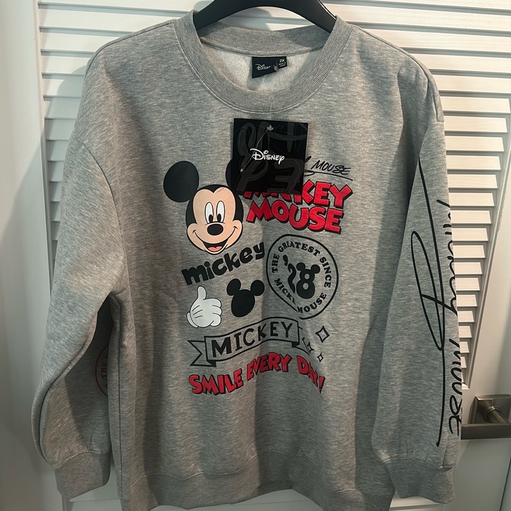 NWT Disney’s Mickey Mouse Sweat Shirt with writing on the sleeves and front.